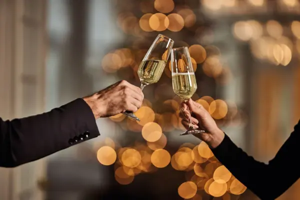 Anstoßen mit Sekt Zwei Hände halten Weingläser.