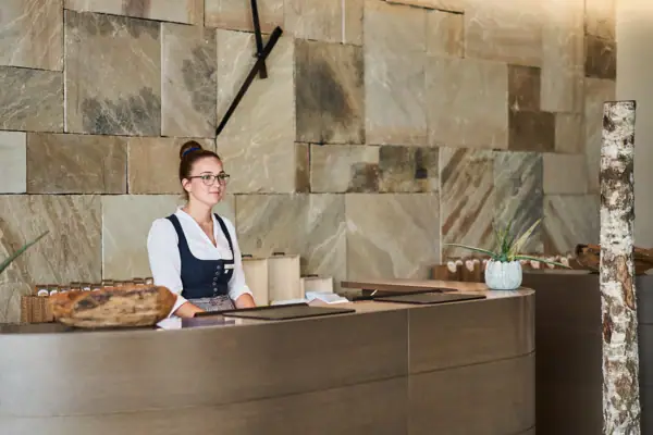 Rezeption Eine Frau steht hinter einem Tresen.