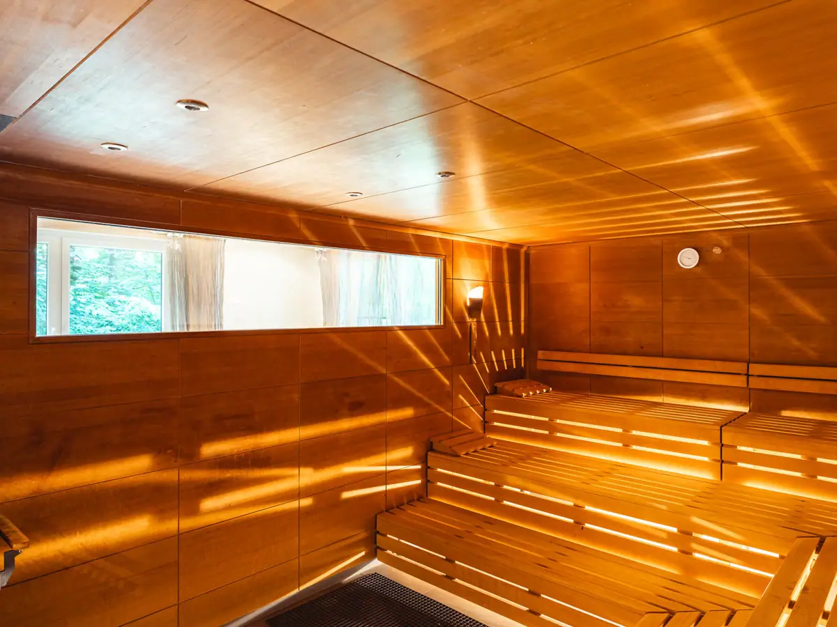 Saunabereich aja Bad Saarow Holzsauna mit Sonnenstrahlen, die durch die Wände scheinen.