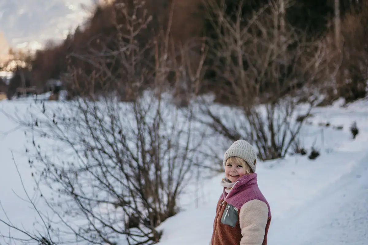 Ein Kind steht im Schnee.