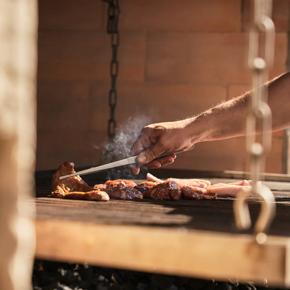 Eine Person grillt Fleisch.
