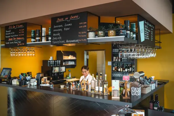 JEDERMANNS Restaurant Travemünde Frau hinter einer Bar mit Flaschen im Hintergrund