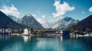 Das Fürstenhaus am Achensee, umgeben von Bäumen und Bergen.