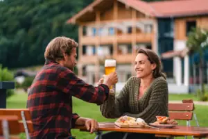 Ein Mann und eine Frau sitzen an einem Tisch mit Essen und Getränken.