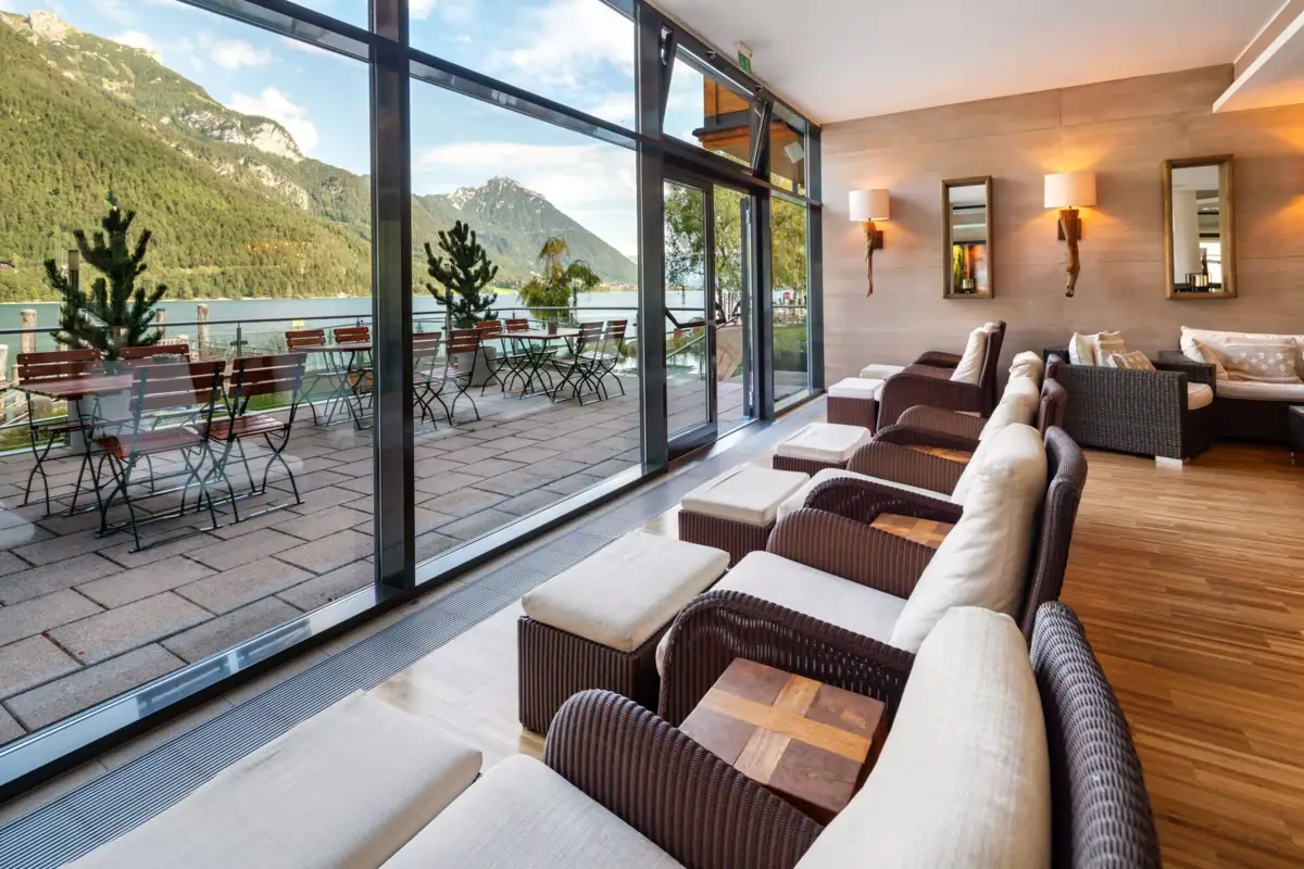 Ein Zimmer mit Tischen und Stühlen, das einen Blick auf die Berge bietet.