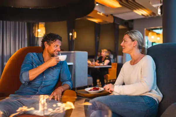 Kaffeepause Ein Mann und eine Frau sitzen an einem Tisch mit Essen.