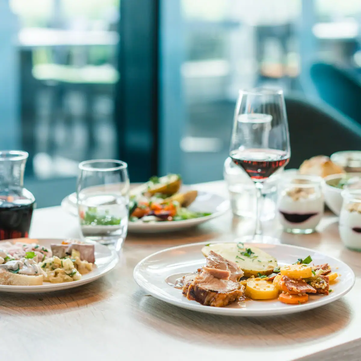 Ein Tisch mit Tellern voller Speisen und Gläsern Wein.