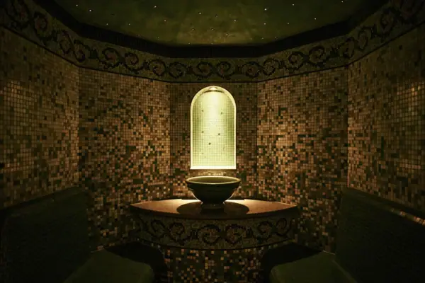 Ein Dampfbad mit Waschbecken und Bänken.