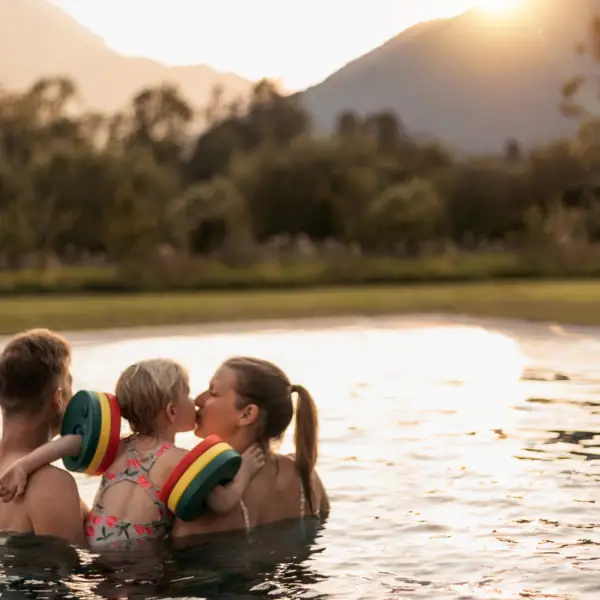 Eine Gruppe von Menschen im Pool, ein Kind gibt einen Kuss.