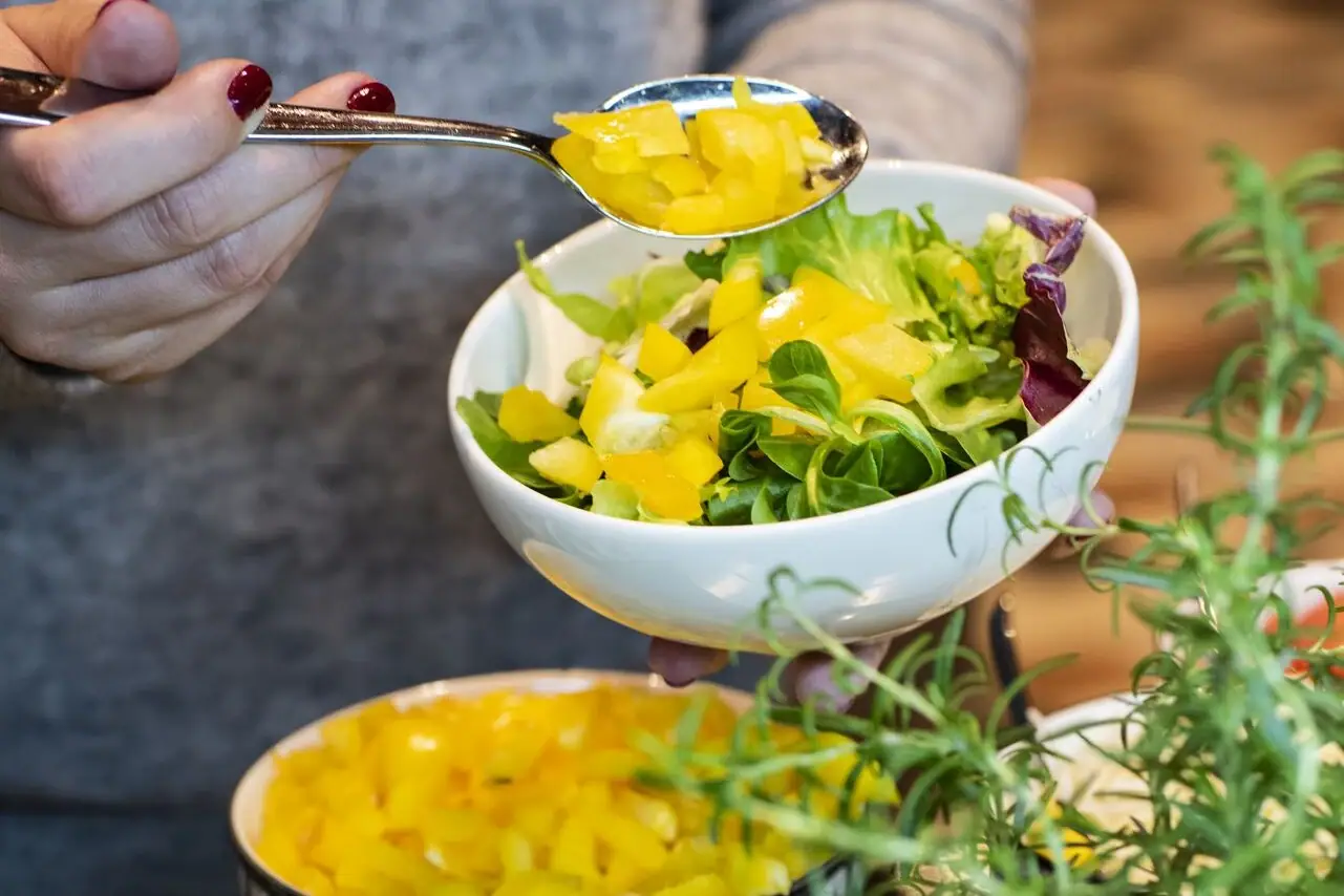 Eine Person füllt Essen in Schüsseln.