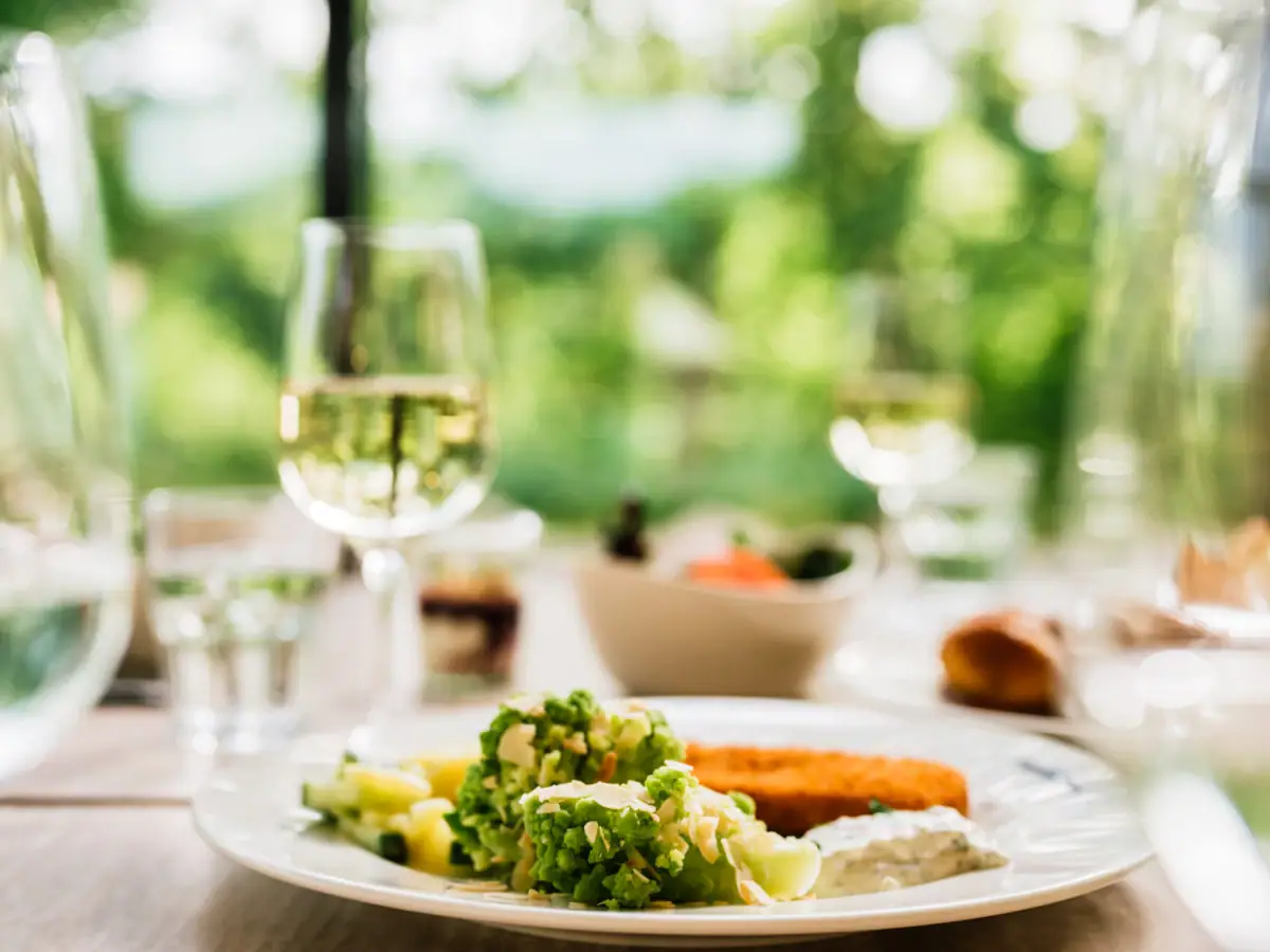 Restaurant aja Bad Saarow Ein Teller mit Essen und ein Glas Wein.