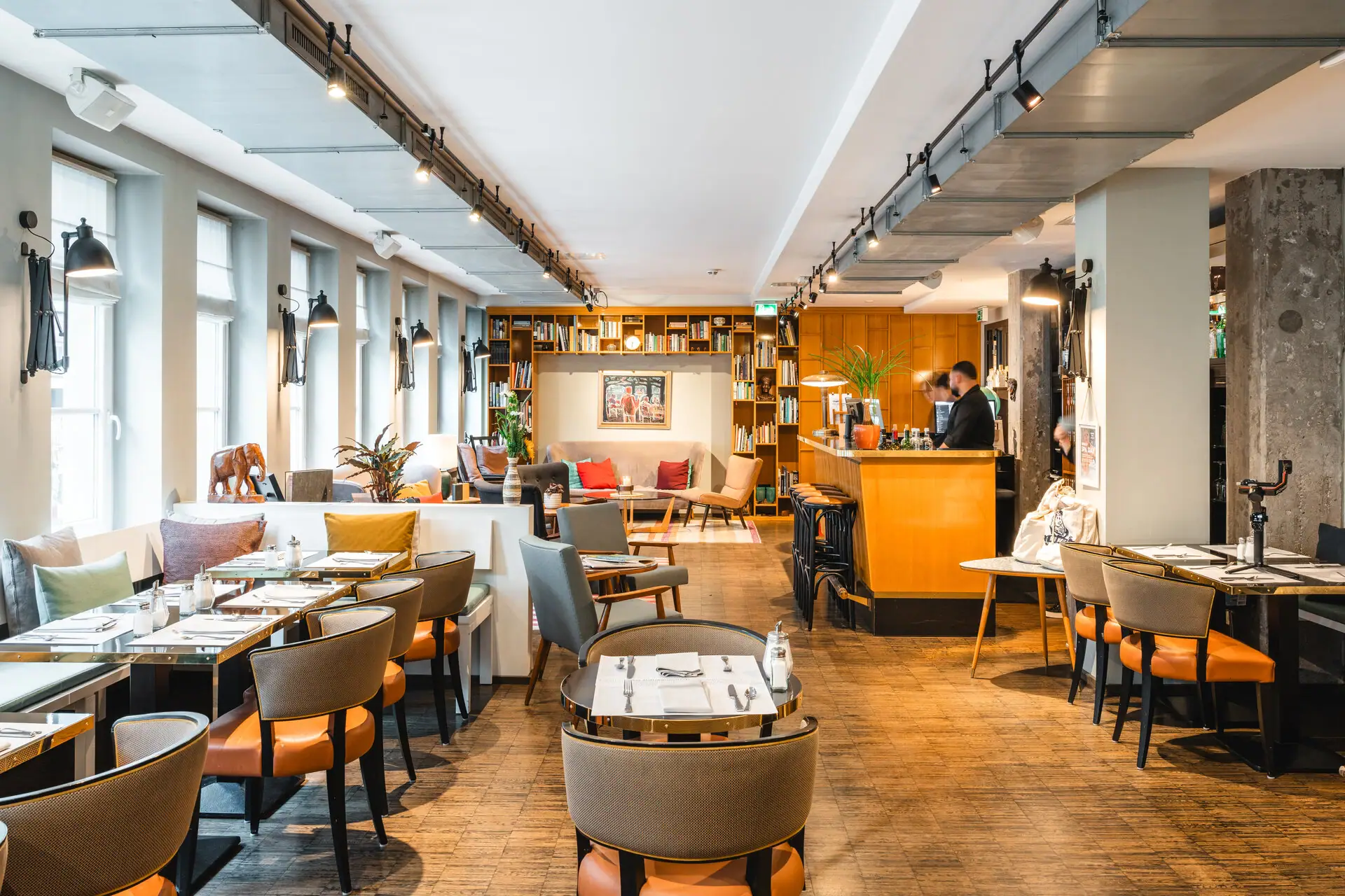 Lobby HENRI Hamburg Ein Restaurant mit Tischen und Stühlen.