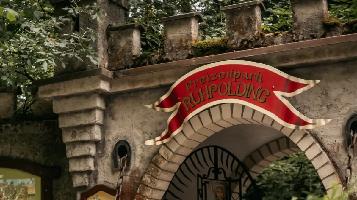 Mädchen steht vor einem Gebäude mit Blumentopf.