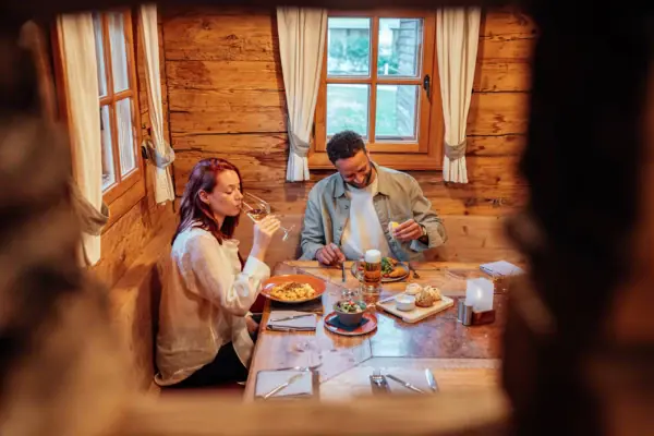 Ein Mann und eine Frau sitzen an einem Tisch mit Essen und Getränken.