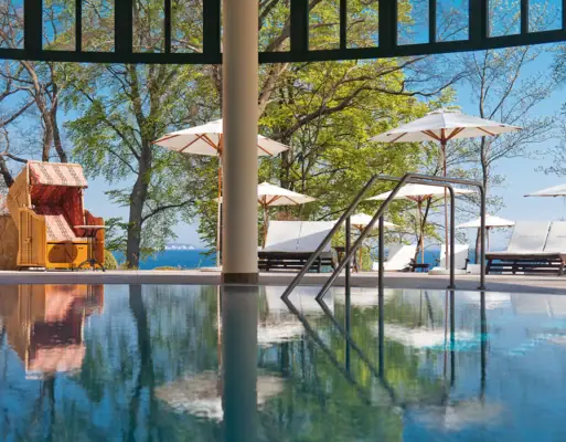 Pool Ein Pool mit einem Liegestuhl und Sonnenschirmen.