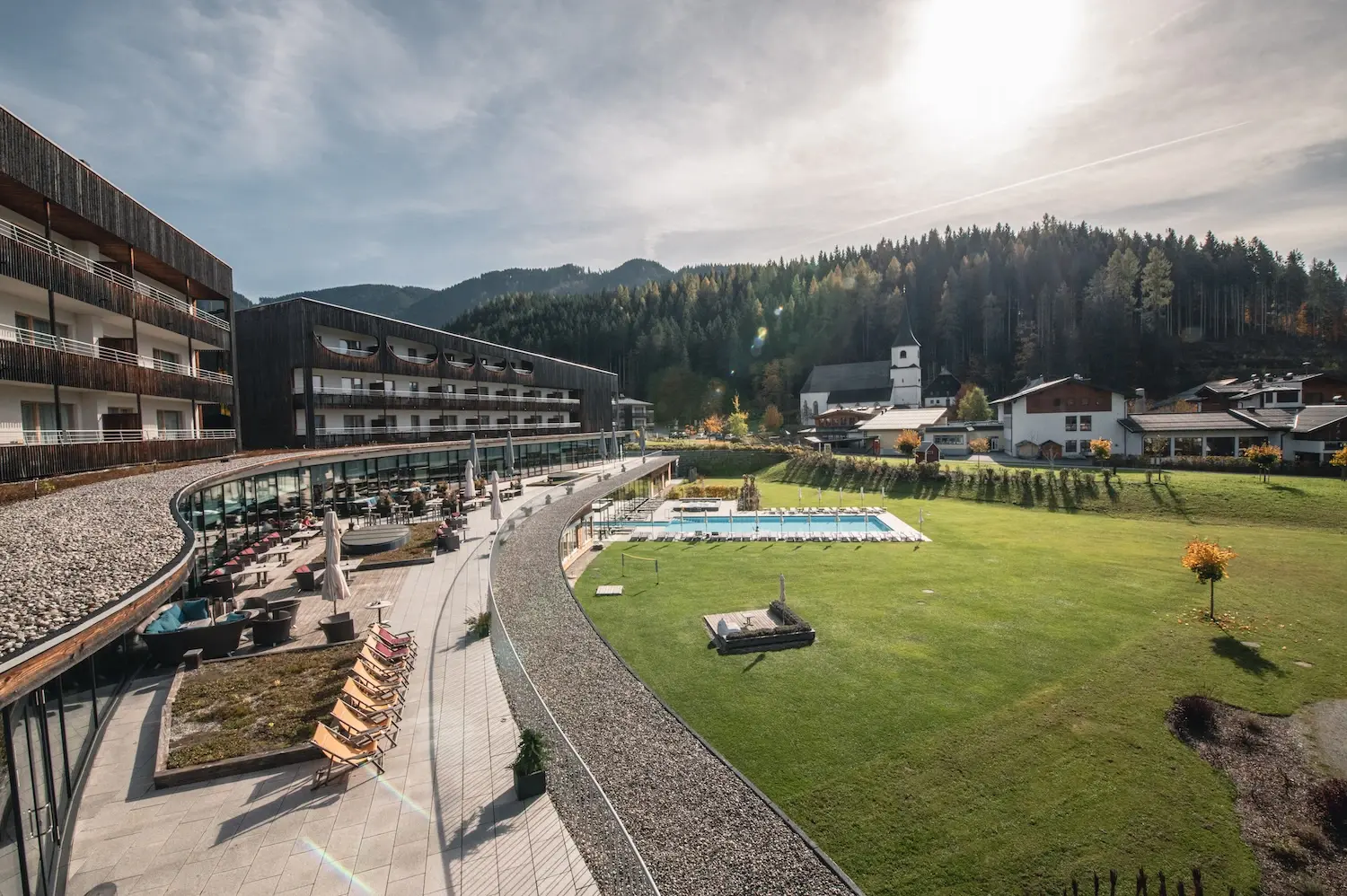 Das aja Werfenweng mit Rasenfläche und Swimmingpool inmitten einer Berglandschaft.