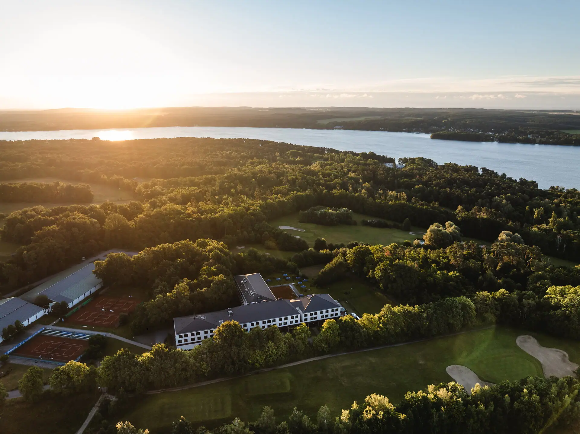 Großer Gewässer mit einem Gebäude und Bäumen im Vordergrund.