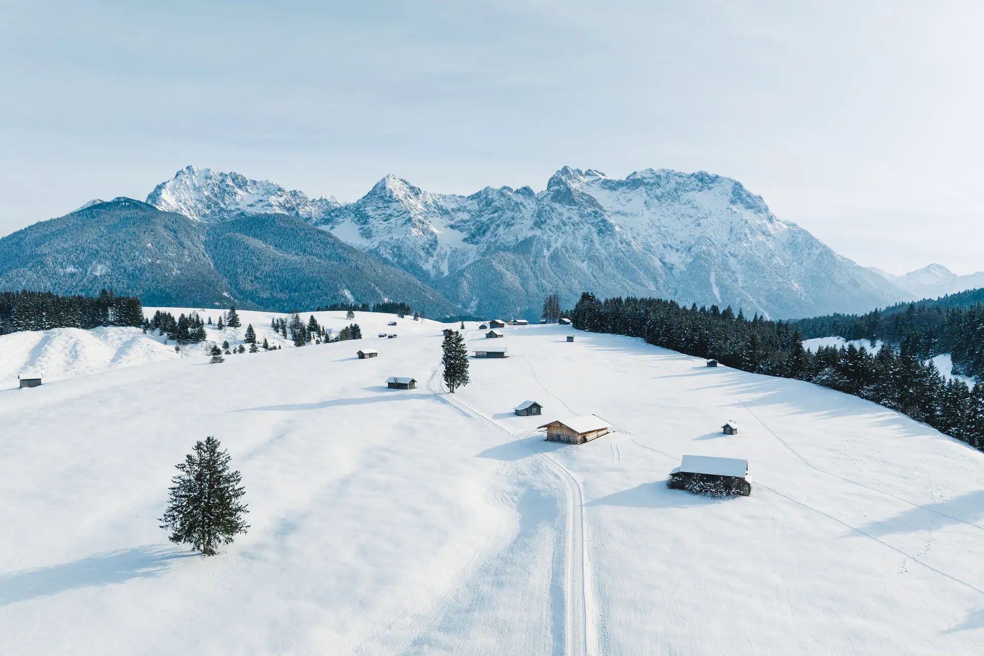 Verschneite Landschaft mit Häusern und Bäumen.