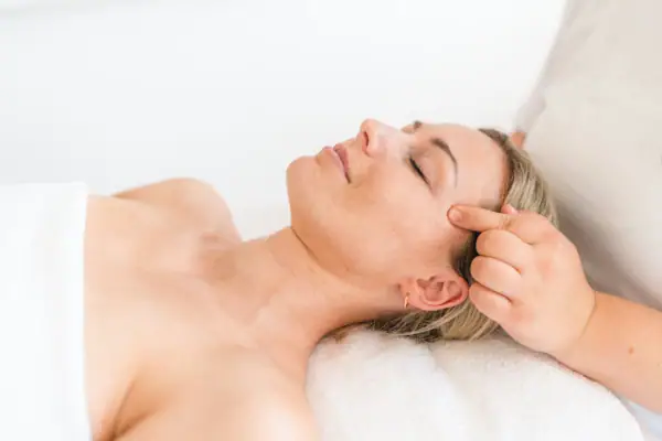 Frau liegt auf einem Massagetisch.