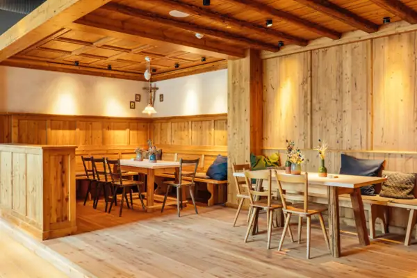 Ein Raum mit Holzwänden, Tischen und Stühlen.