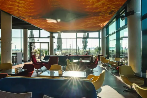 Bar mit Sitzgelegenheiten Ein Raum mit Tischen und Stühlen.