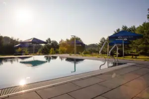 Ein Pool mit blauen Sonnenschirmen.