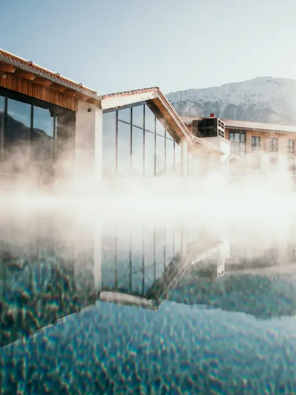 Ein Gebäude mit einem Gewässer und einem Berg im Hintergrund.