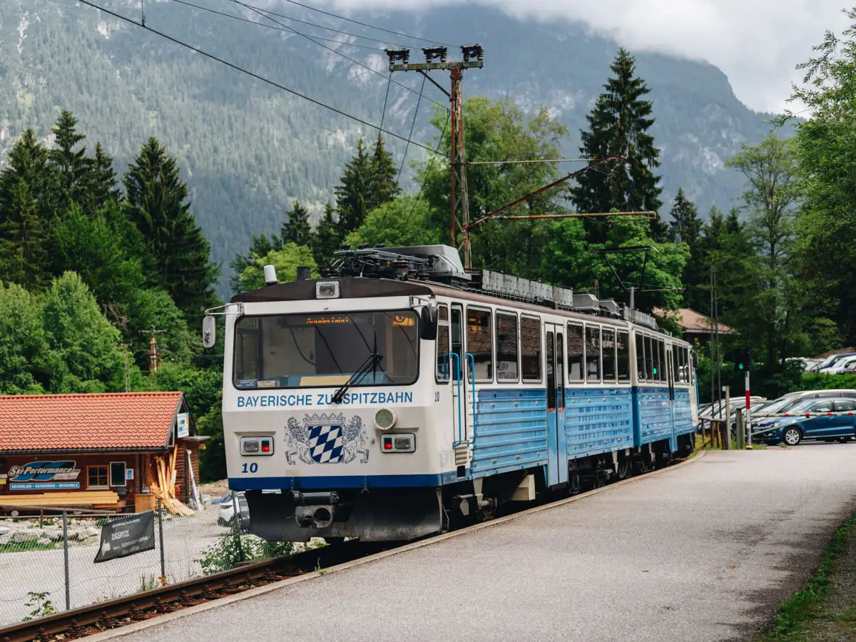 Bayerische Zugspitzbahn Ein Zug fährt durch verschneite Landschaft.