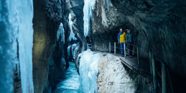 Personen stehen auf einer Brücke in der Partnachklamm.