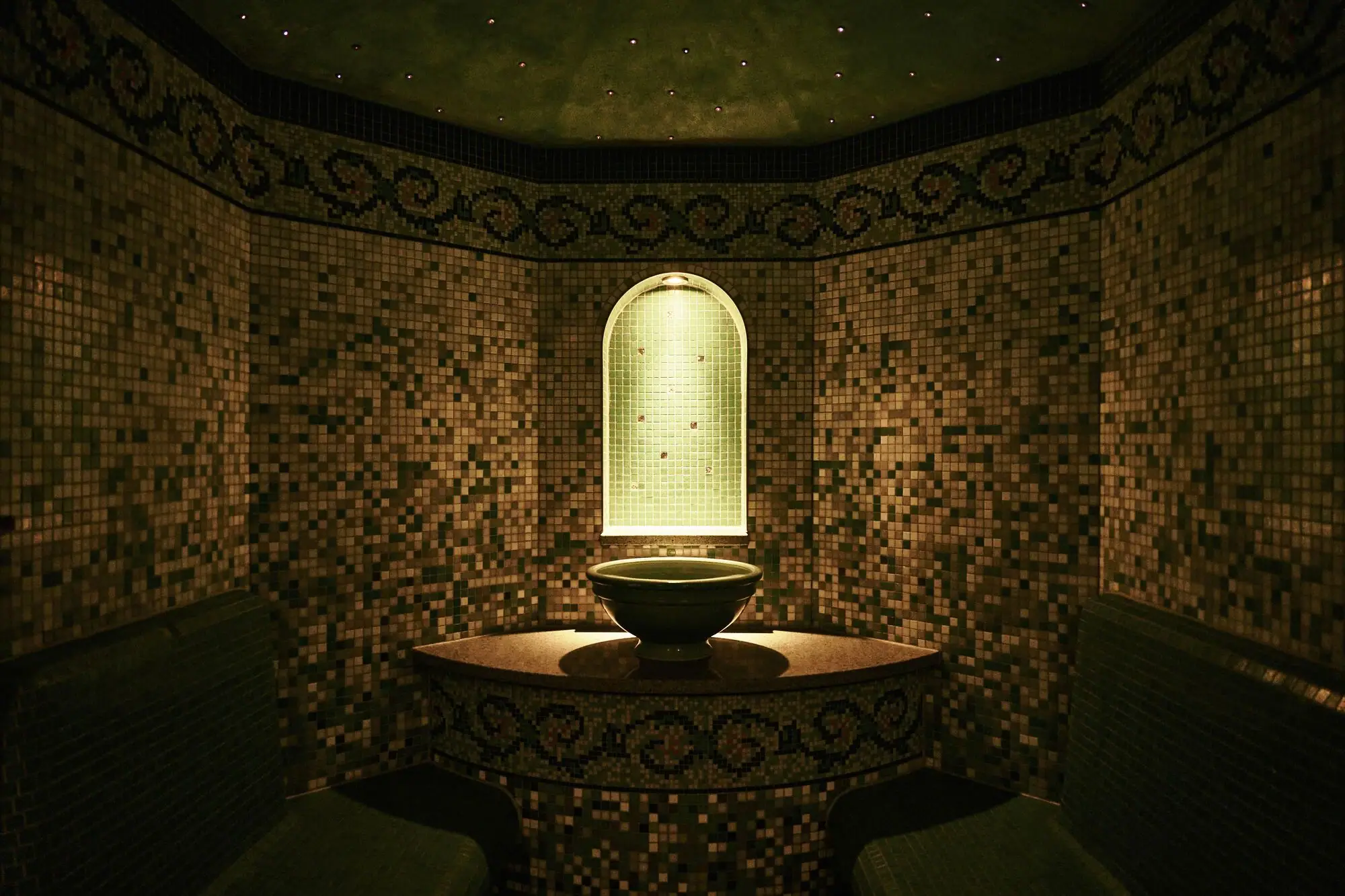 Dampfbad Ein Dampfbad mit Waschbecken und Bänken.