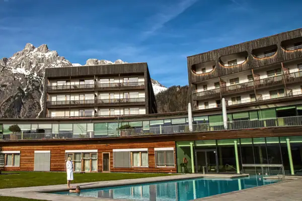 Person steht vor einem Schwimmbecken im Freien.