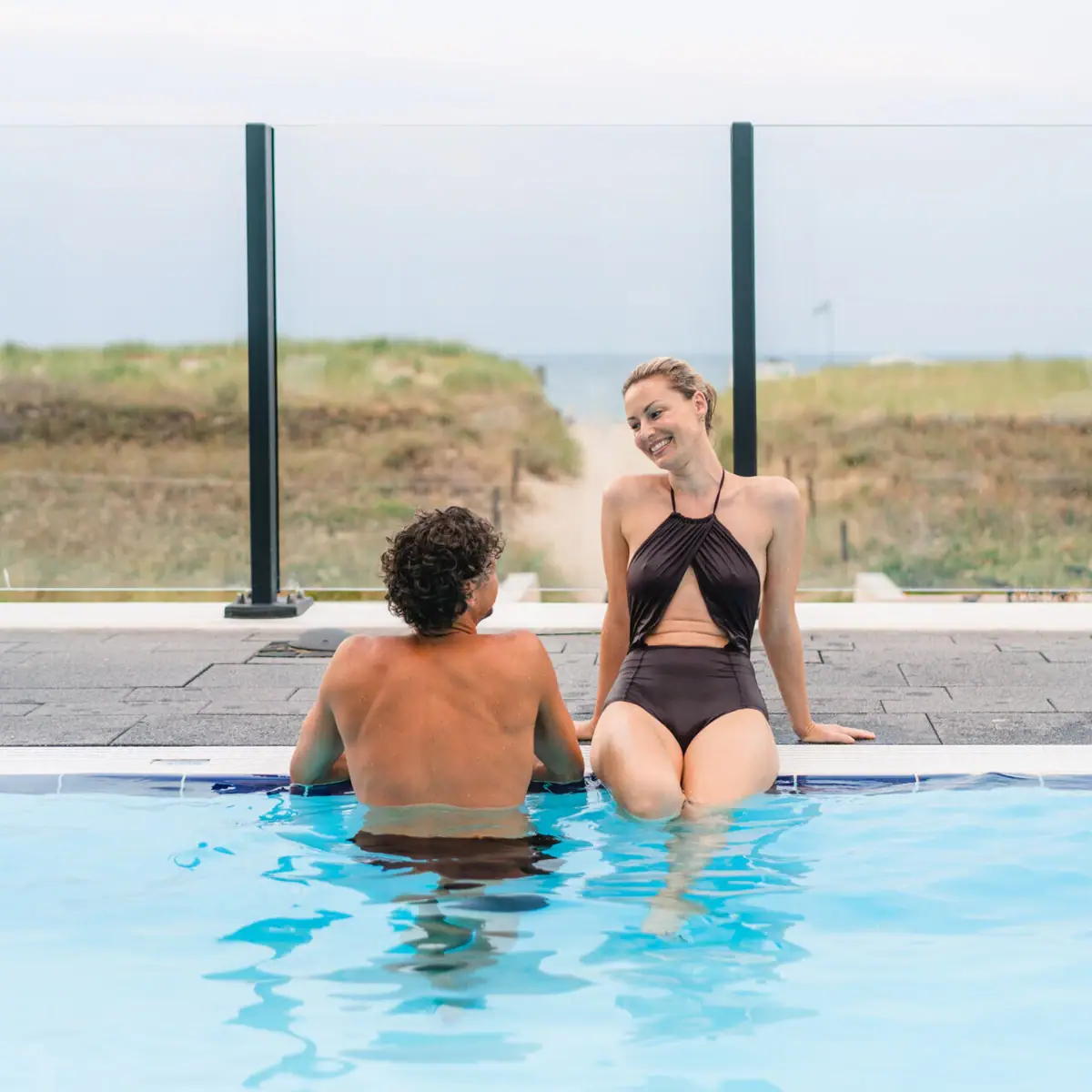 Ein Mann und eine Frau sitzen in einem Pool.