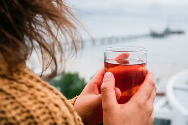 Eine Person hält ein Glas mit Getränk.