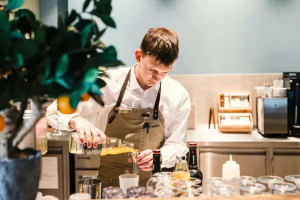 Ein Mann gießt Flüssigkeit in ein Glas.