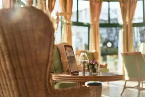 Lounge Ein Korbsessel neben einem Tisch mit einer Lampe darauf.