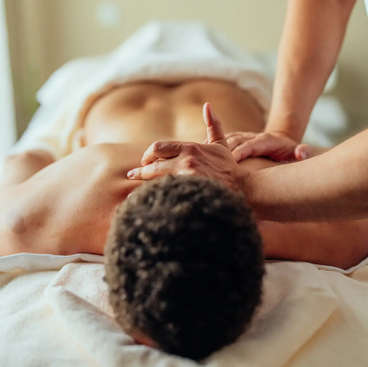 Ein Mann liegt auf einem Massagetisch.
