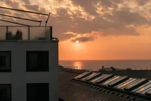 Ein Gebäude mit Dach vor einem Sonnenuntergang.