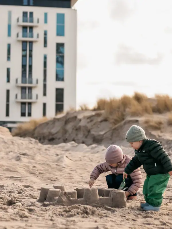 Spielen am Strand Zwei Kinder spielen im Sand am Strand.