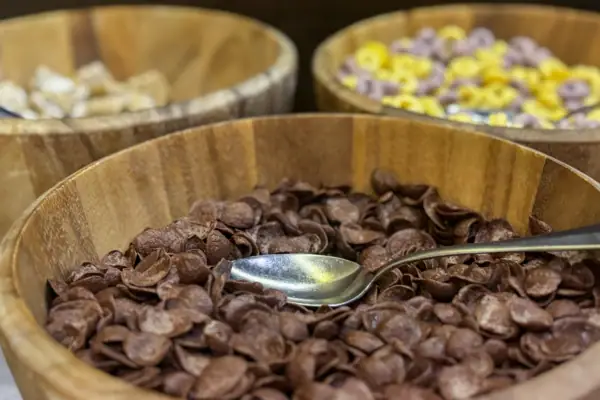 Eine Schüssel Cornflakes mit einem Löffel im Hintergrund andere Sorten Cornflakes