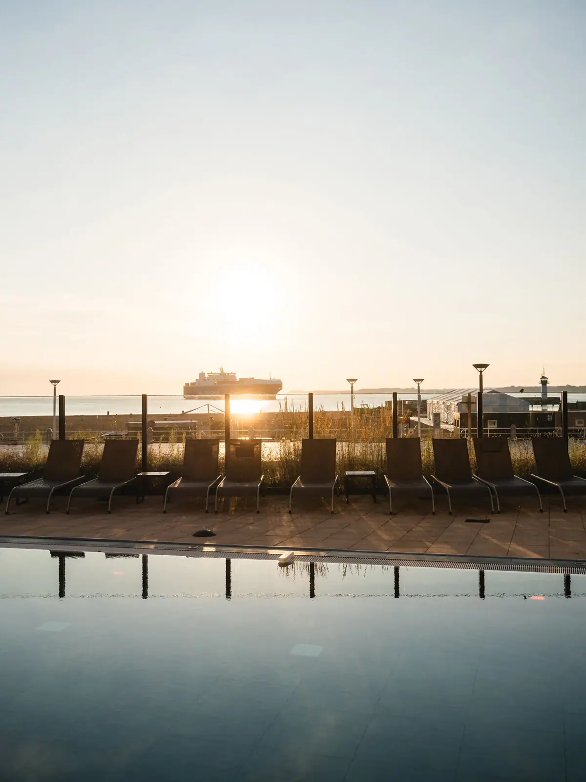 Außenpool aja Travemünde Eine Reihe von Stühlen am Pool im Freien.