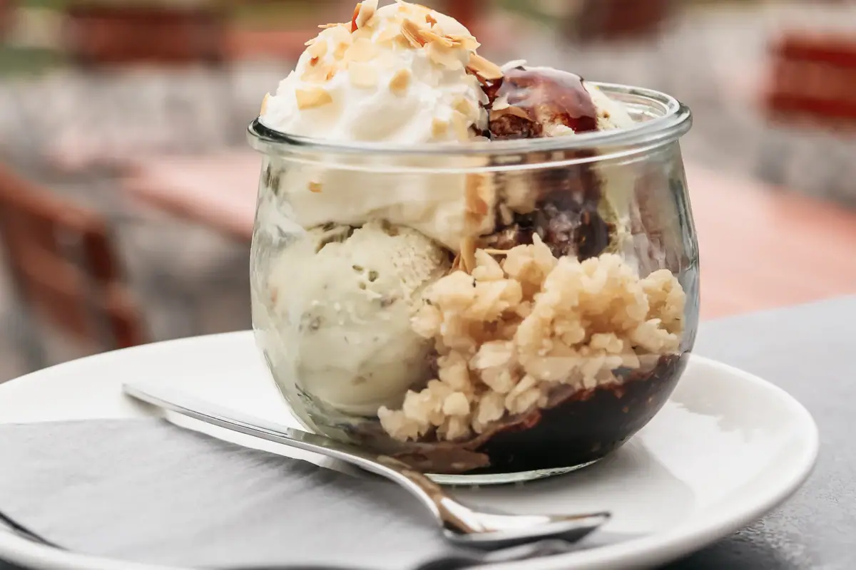 Glasschüssel mit Eiscreme und einer Gabel auf einem Tisch