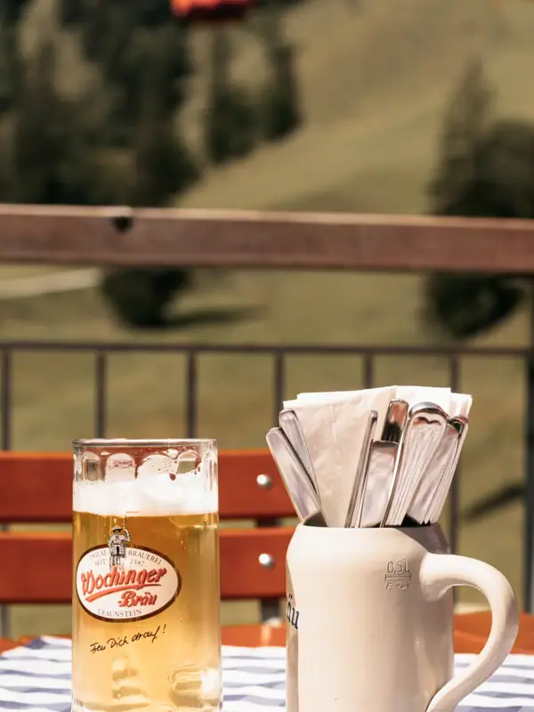 Ein Glas Bier und ein Becher auf einem Tisch.