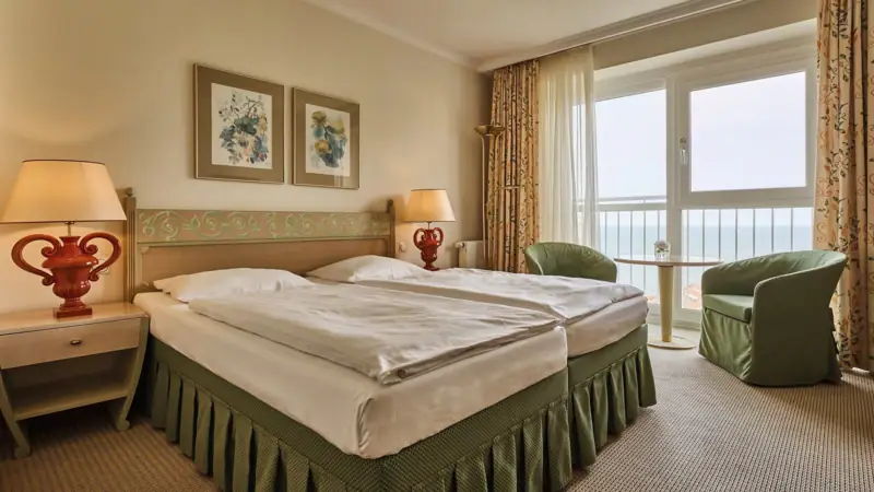 Hotelzimmer mit Bett und Fenster.