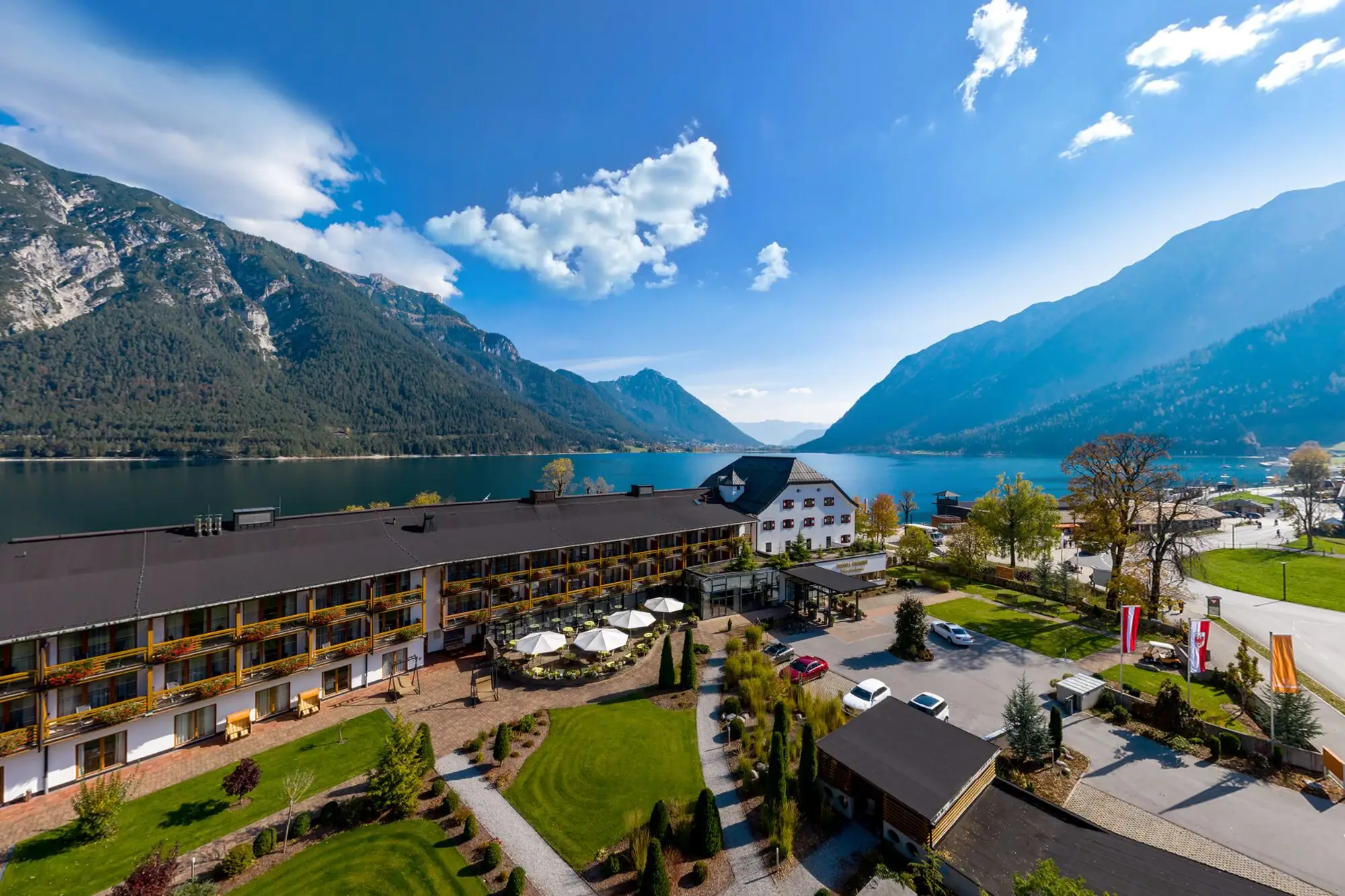 Ein Gebäude in der Nähe eines Sees mit Bäumen und Wolken am Himmel.