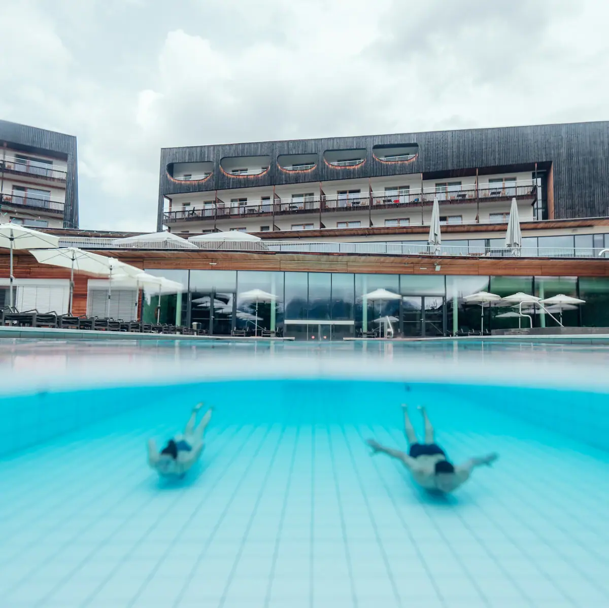 Tauchen im Außenpool Menschen schwimmen in einem Pool.