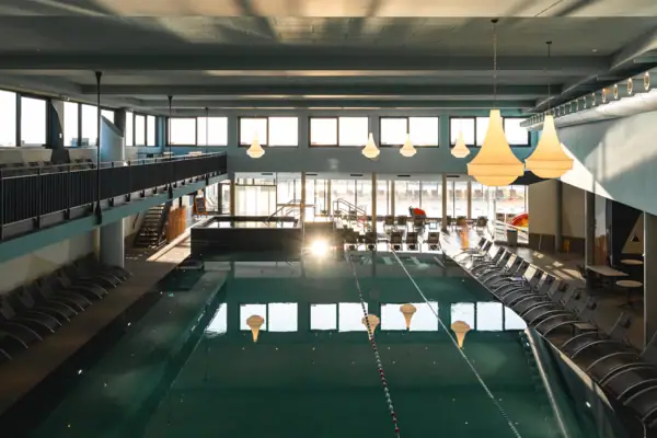 Hallenbad mit blauem Wasser und Decke im Hintergrund