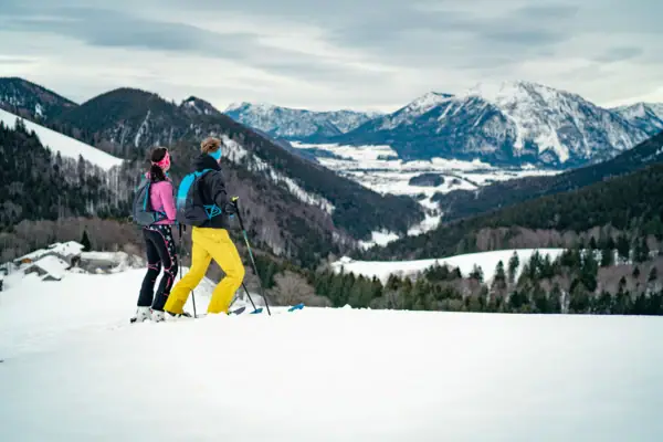 Winter in Ruhpolding Ein Paar beim Skifahren auf einem verschneiten Berg.