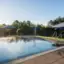Ein Pool mit Sonnenschirmen und Gras.