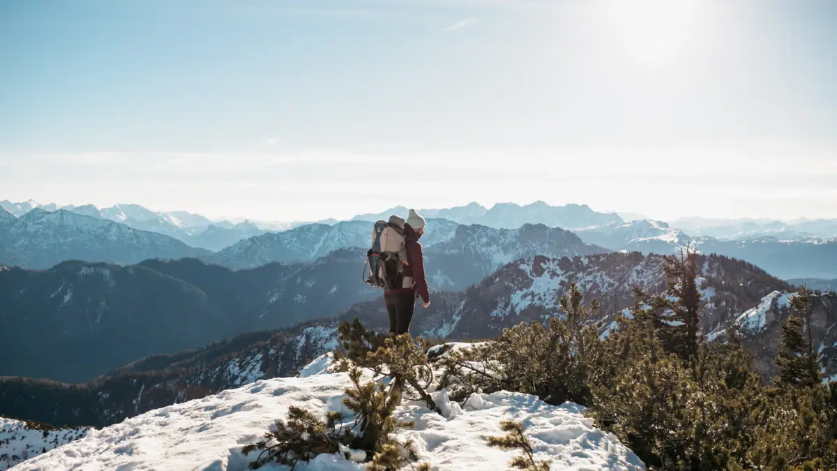 Eine Person steht auf einem verschneiten Berg.