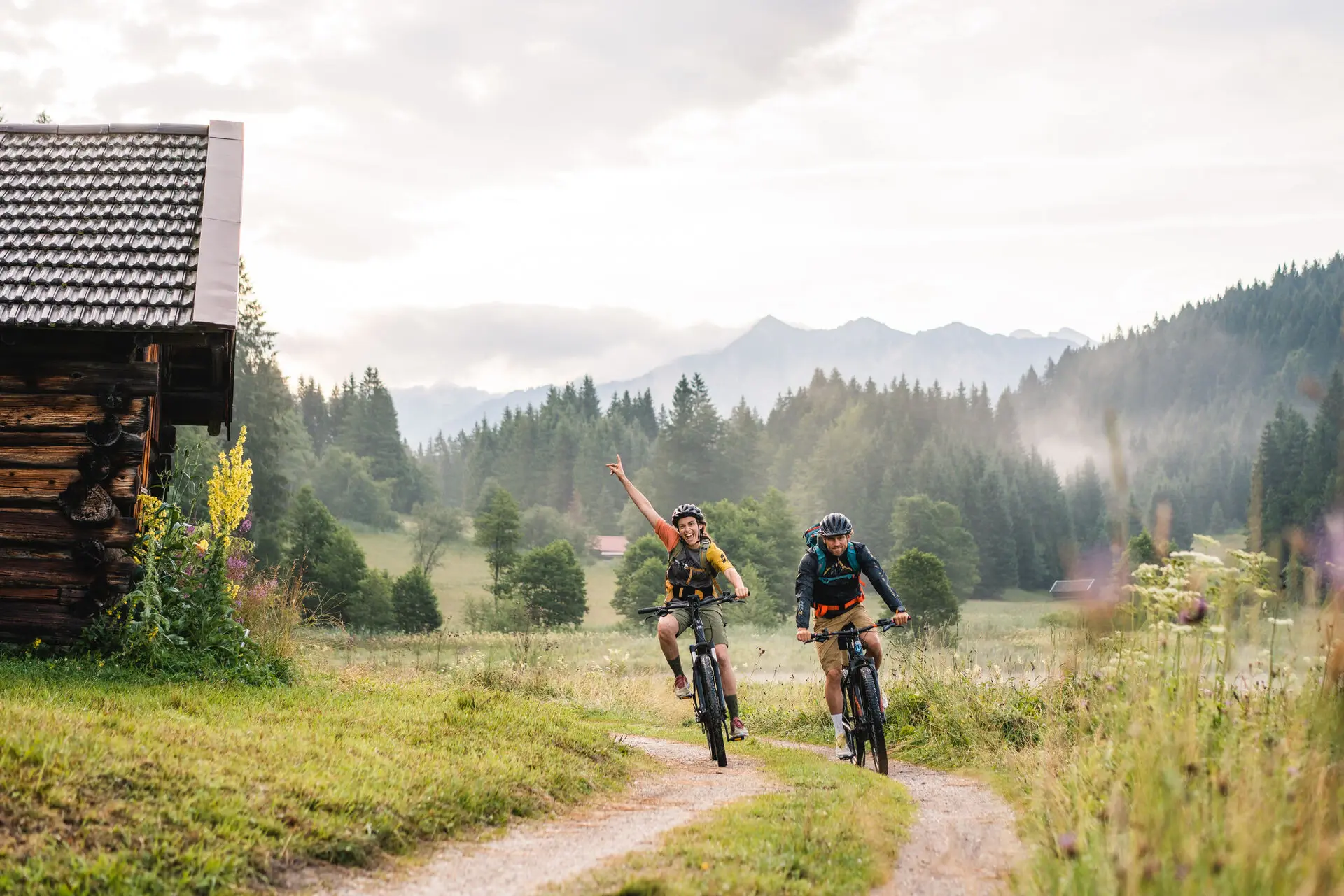 Zwei Personen fahren auf einem Weg durch die Berge Fahrrad.